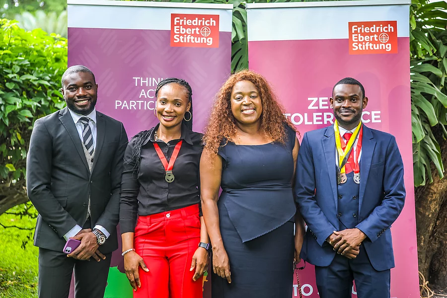 Young Leaders celebrate their graduation in front of an FES roll-up banner.